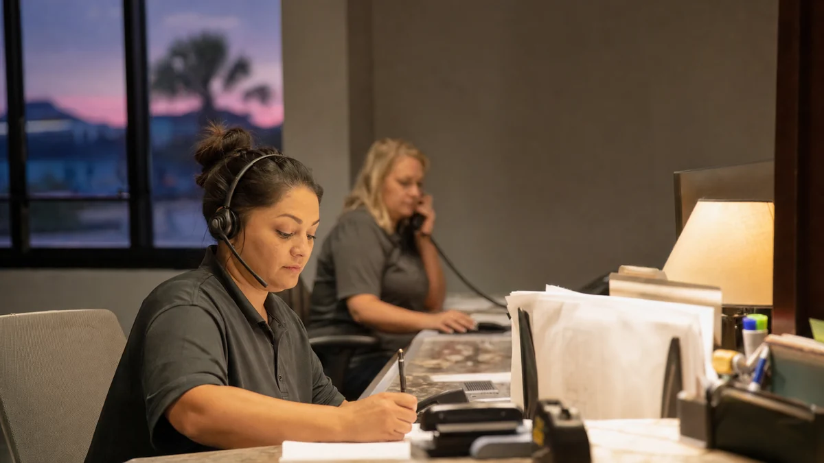 HVAC office staff answering calls in the evening during a busy peak-season week